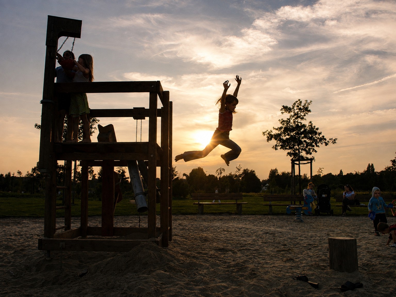 A child caught mid-jump in warm evening backlight